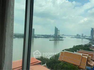 Stunning river view from high-rise window overlooking cityscape and bridge.