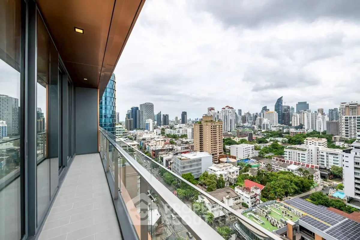 Stunning cityscape view from a modern high-rise balcony with sleek glass railing.
