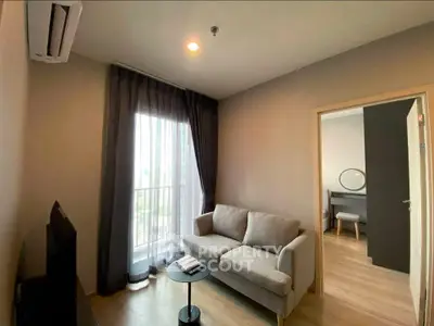 Modern living room with balcony view, cozy sofa, and stylish decor in a contemporary apartment.