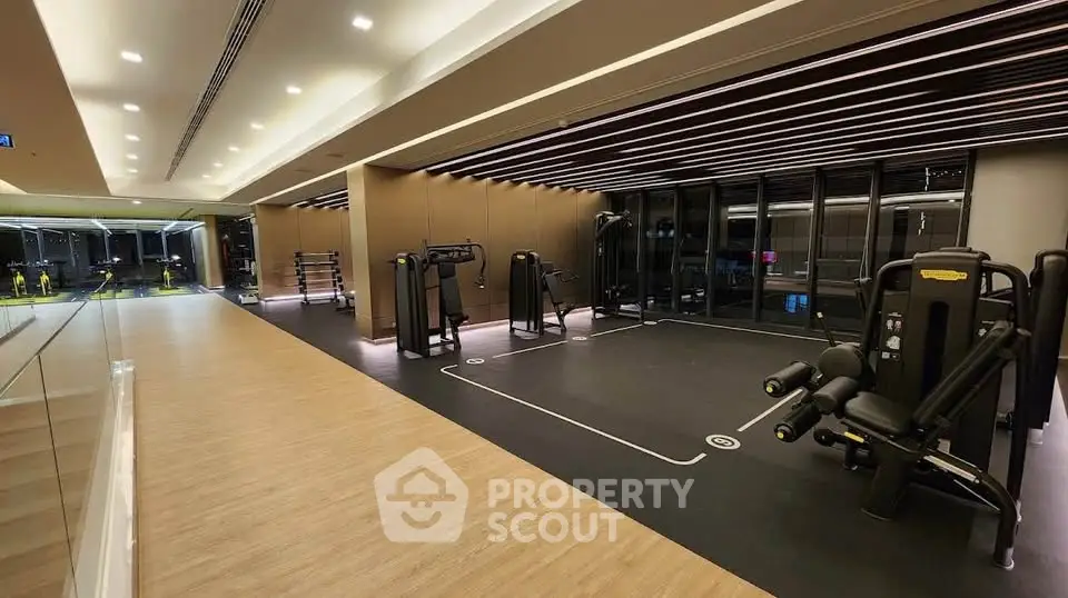 Modern gym with state-of-the-art equipment and sleek design in luxury residential building.