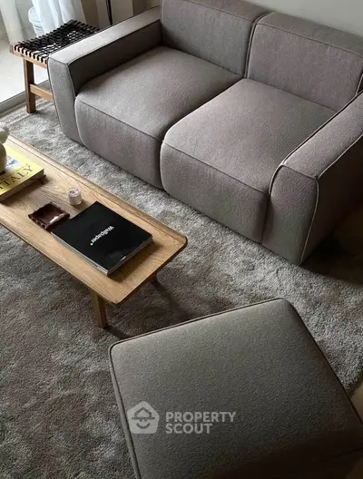 Stylish modern living room with plush gray sofa and elegant wooden coffee table.