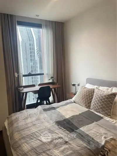 Modern bedroom with city view, featuring a cozy bed and a stylish work desk by the window.