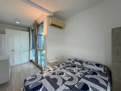 Modern bedroom with stylish bedding, large window, and air conditioning unit.