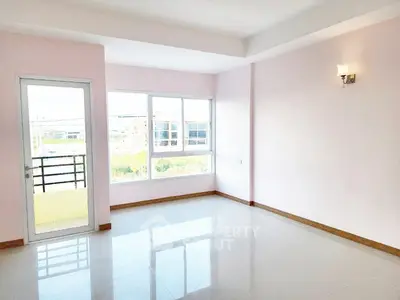 Bright empty room with large windows and balcony access