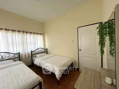 Cozy bedroom with twin beds and natural light, perfect for restful nights.