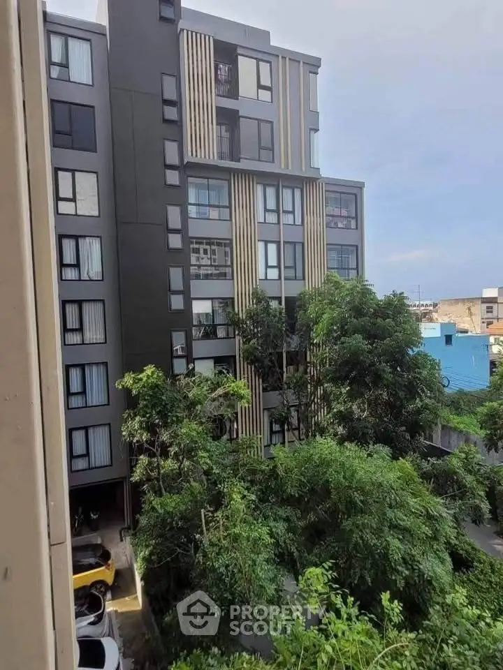 Modern apartment building with lush greenery and urban surroundings