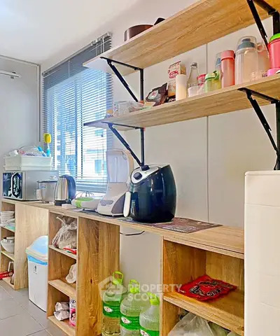 Modern kitchen with open shelving and appliances, featuring bright natural light and sleek design.