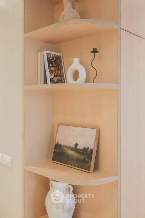 Elegant built-in wooden shelves with decorative items in a modern home interior.
