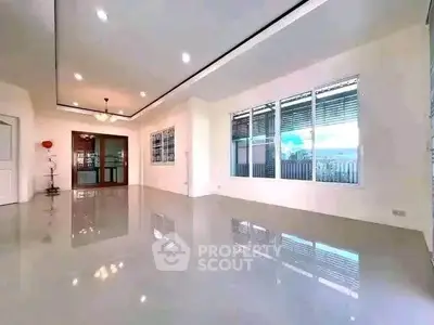 Spacious modern living room with glossy floors and large windows for natural light.
