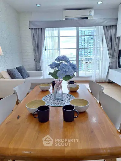 Bright and modern living room with dining area, featuring large windows and city view.