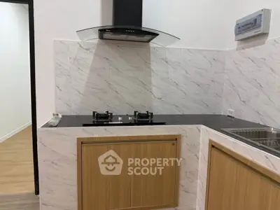 Modern kitchen with gas stove and sleek cabinetry in a stylish apartment.