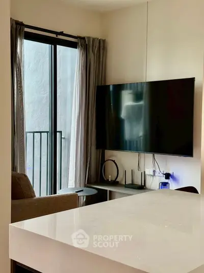 Modern living room with wall-mounted TV and balcony access