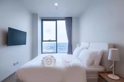 Modern bedroom with large window offering stunning city view, featuring sleek decor and mounted TV.