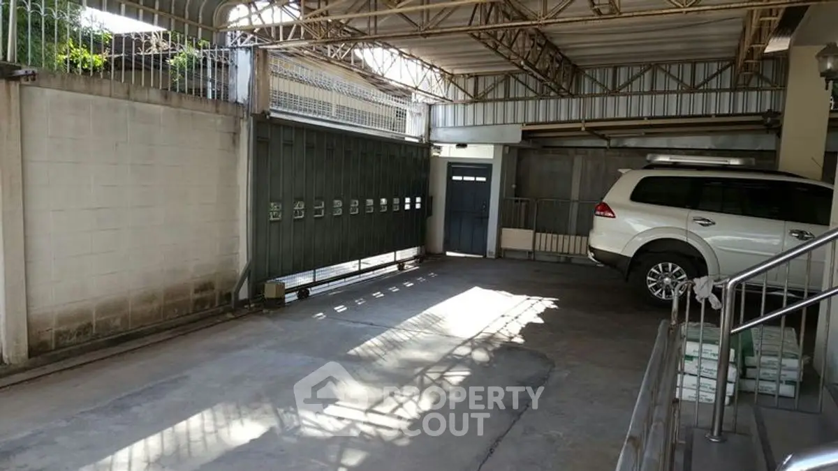 Spacious covered parking area with secure gate and ample lighting.