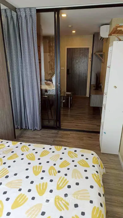 Modern bedroom with sliding glass doors and stylish decor in a cozy apartment.