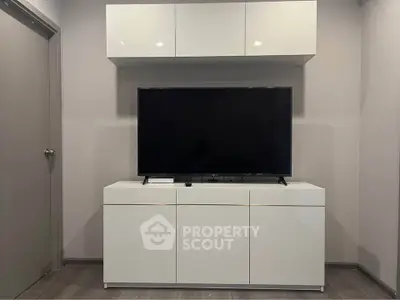 Modern living room with sleek white TV cabinet and mounted storage unit.