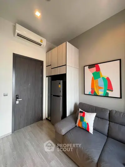 Modern living room with sleek design, featuring a stylish sofa, vibrant artwork, and efficient storage solutions.