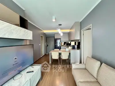 Modern living room with open kitchen, stylish decor, and cozy seating area in a contemporary apartment.