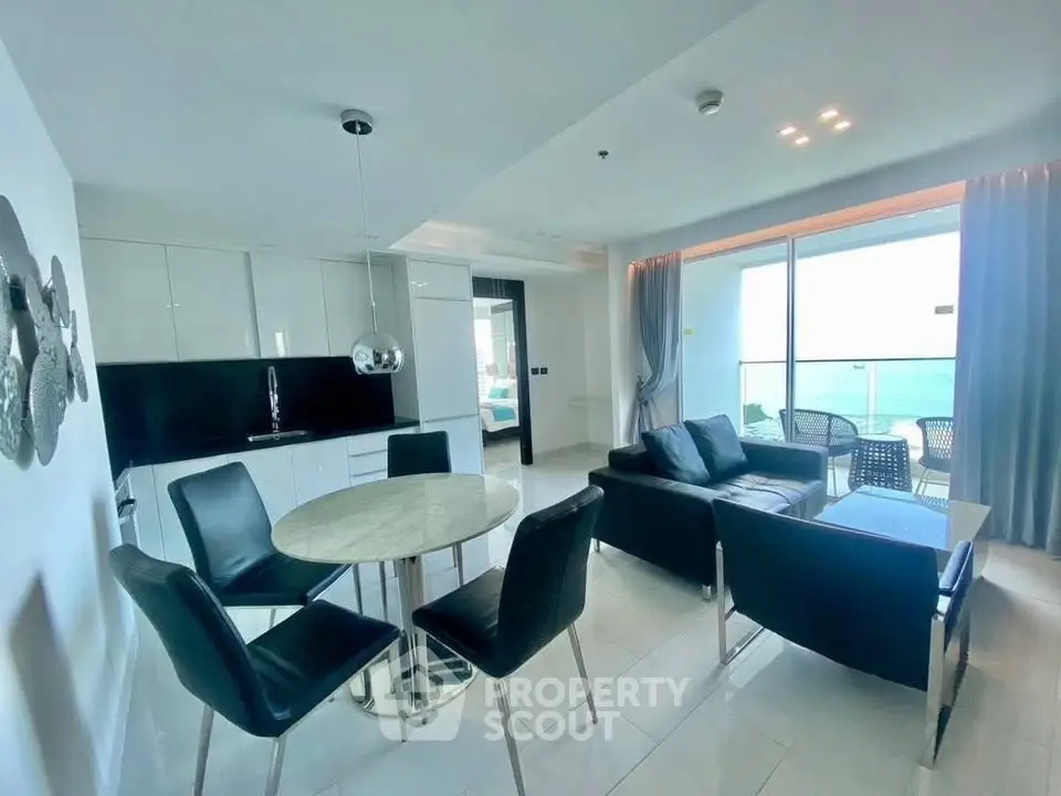 Modern open-plan living room with ocean view and sleek kitchen design.