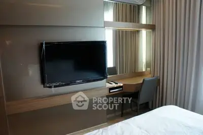 Modern bedroom with wall-mounted TV and sleek desk area