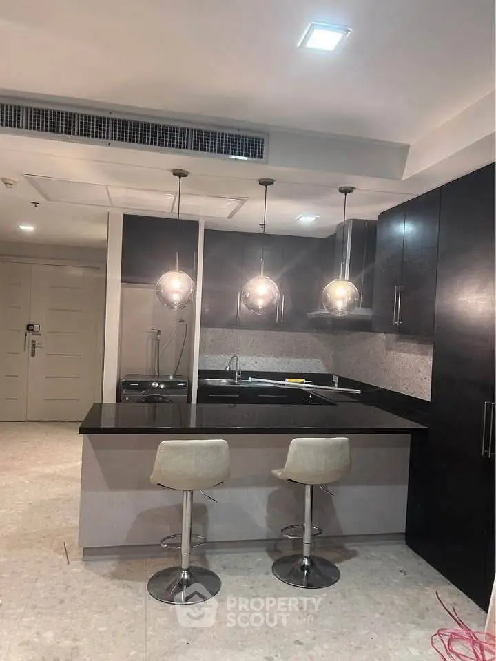 Modern kitchen with sleek black countertops and stylish pendant lighting
