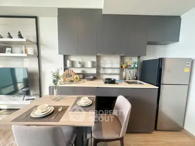 Modern kitchen with sleek cabinetry, dining area, and stainless steel appliances in a stylish apartment.