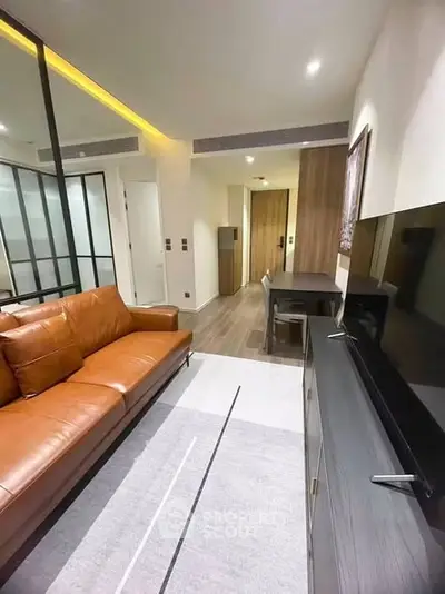 Modern living room with leather sofa and sleek TV unit in a stylish apartment.