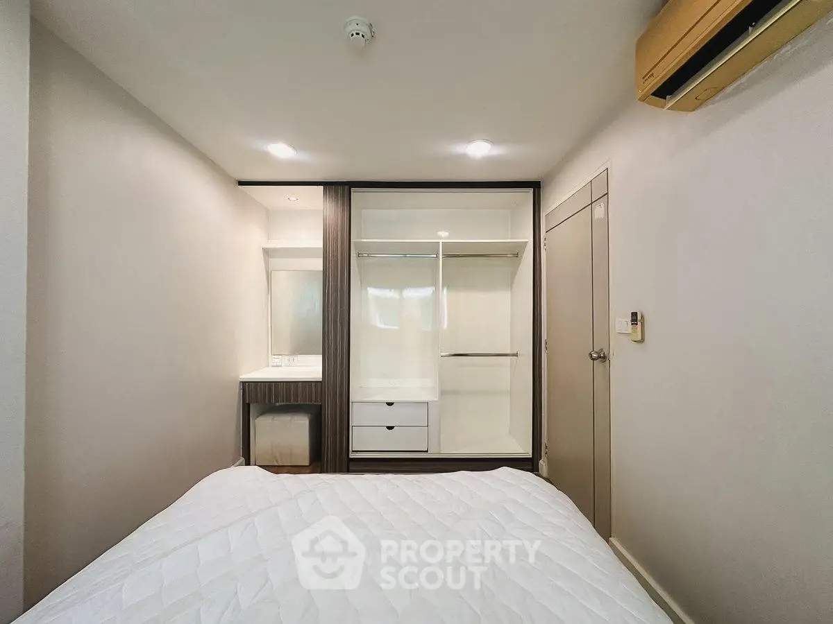 Modern bedroom with built-in wardrobe and air conditioning unit