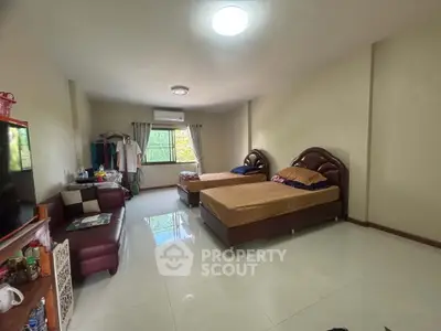 Spacious bedroom with twin beds, cozy seating, and ample natural light.