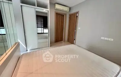 Modern bedroom with built-in wardrobe and air conditioning in a stylish apartment.