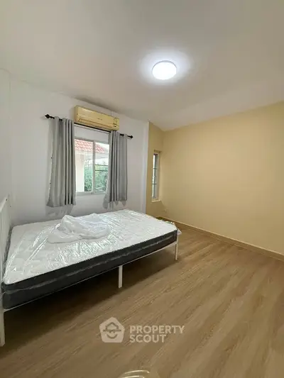 Spacious bedroom with natural light and modern flooring, perfect for a cozy retreat.