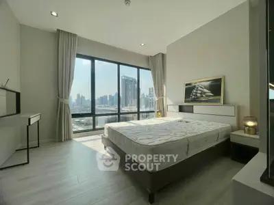 Luxurious bedroom with stunning city view and modern decor in high-rise apartment.