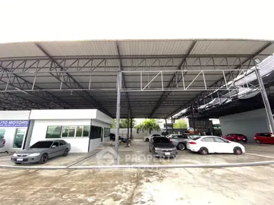 Spacious covered parking area with multiple cars and modern steel structure.