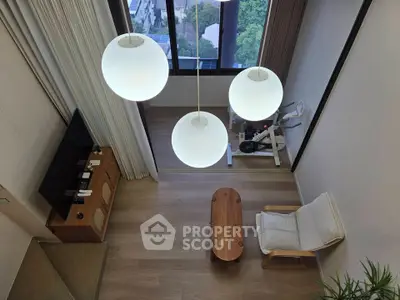 Modern living room with high ceiling, large windows, and stylish lighting overlooking a scenic view.