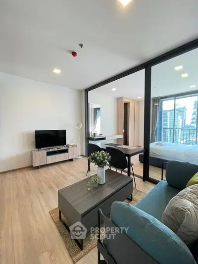 Modern open-plan living room with stylish furniture and city view from the balcony.