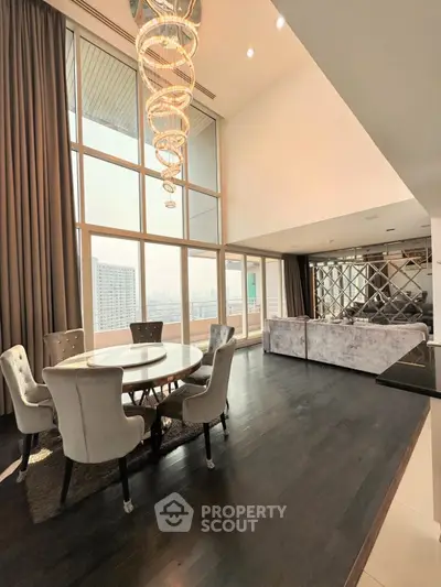 Luxurious high-ceiling living room with elegant chandelier and city view