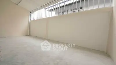 Spacious storage area with high ceiling and natural light