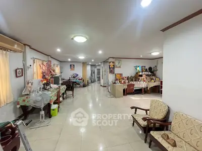 Spacious living room with tiled floors and cozy seating area, perfect for family gatherings.