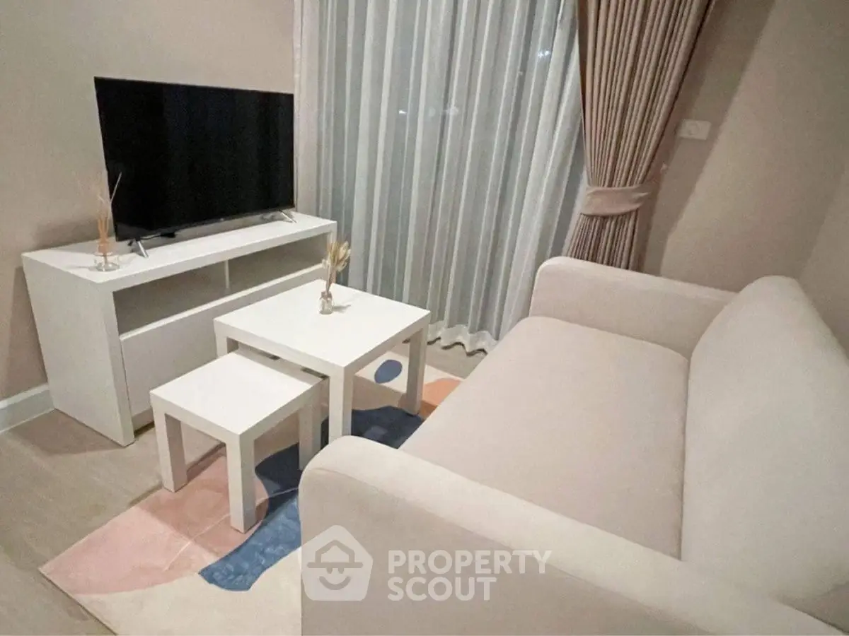Cozy living room with modern sofa, TV, and stylish decor in a chic apartment.