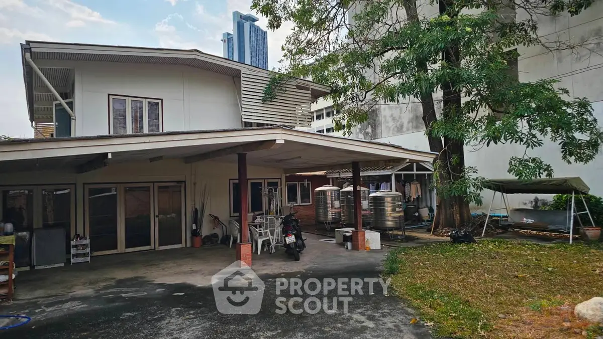 Charming two-story house with spacious outdoor area and covered parking, ideal for family living in urban setting.
