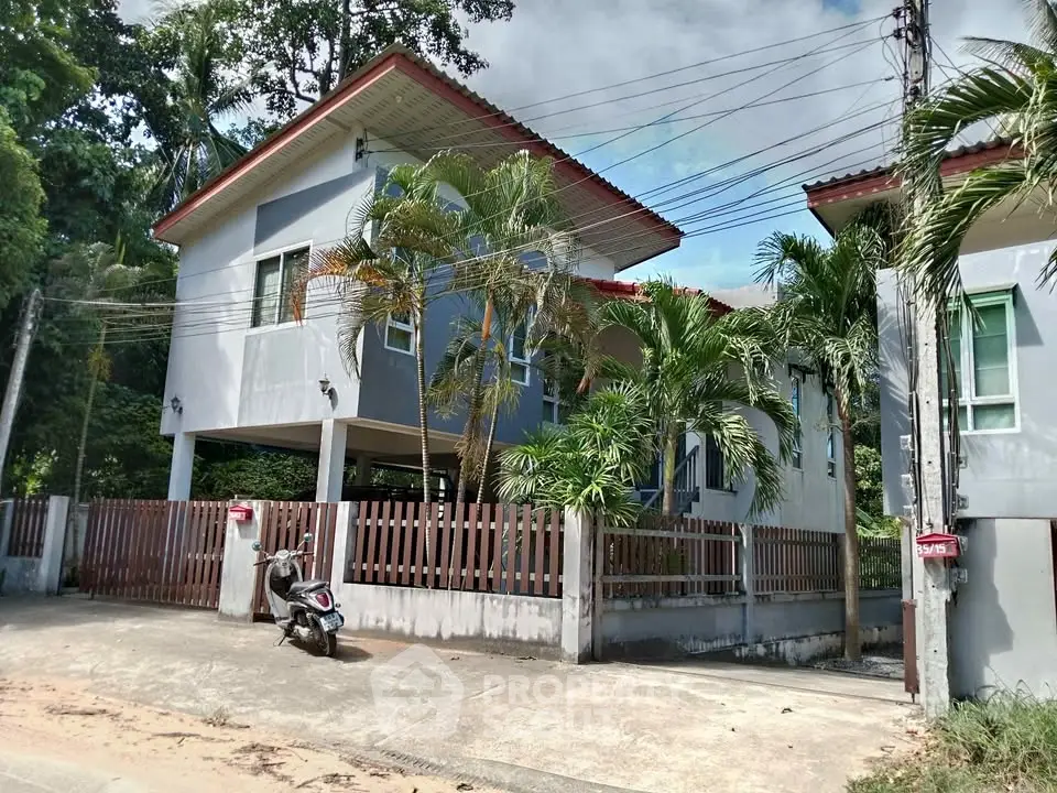 Charming two-story house with lush greenery and modern design in a serene neighborhood.