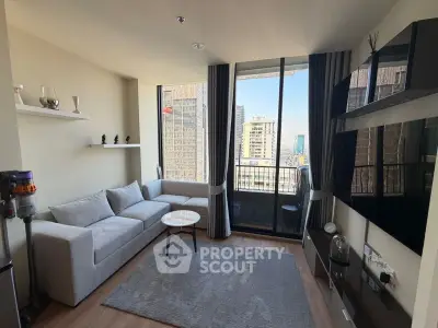 Modern living room with large windows and city view, featuring sleek furniture and stylish decor.