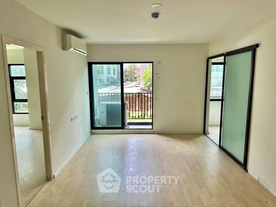 Spacious living room with balcony access and natural light in modern apartment.