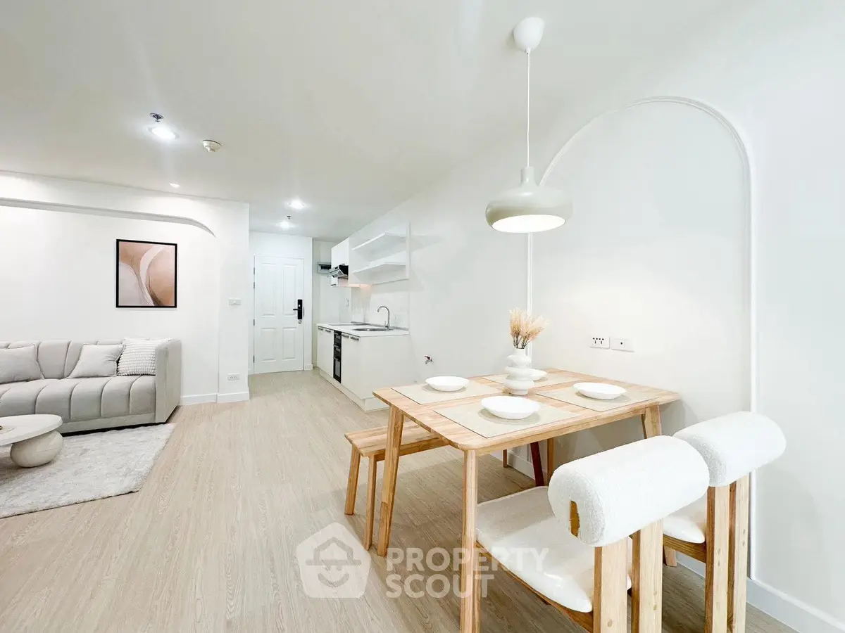 Modern open-plan living room and kitchen with stylish dining area and cozy seating.