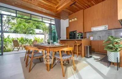 Stunning open-layout kitchen and dining area with garden view, featuring modern wooden furniture and sleek design.