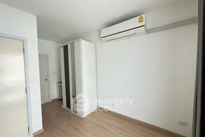 Minimalist bedroom with air conditioning and wooden flooring