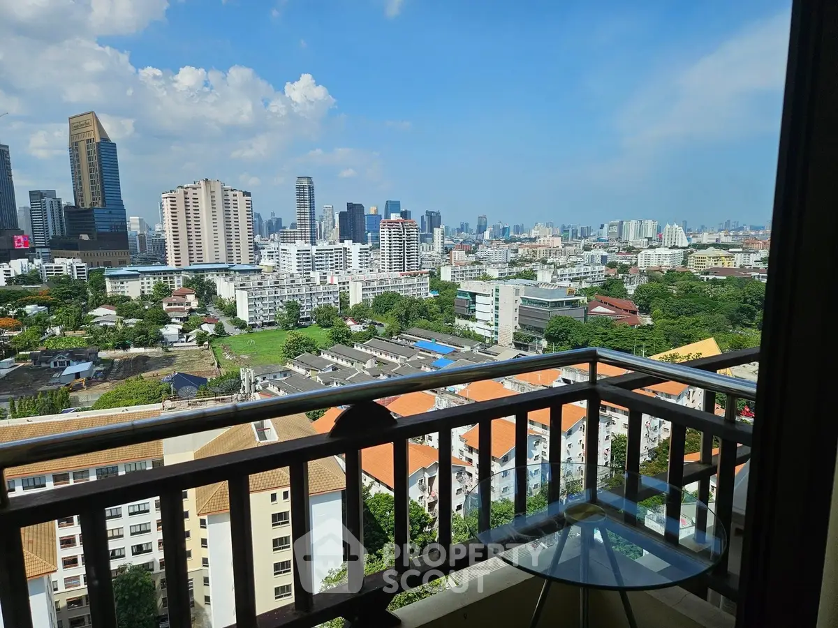Stunning cityscape view from a high-rise balcony with modern glass railing.
