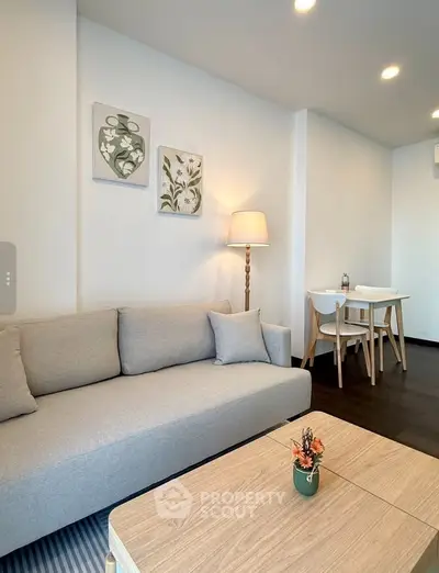 Modern living room with cozy sofa, stylish decor, and elegant dining area in open layout.