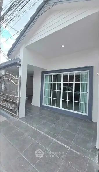Modern house entrance with sliding glass doors and tiled flooring.