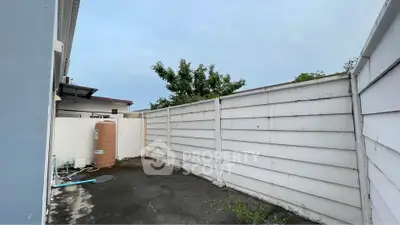 Spacious outdoor area with privacy fence and utility setup, perfect for customization.